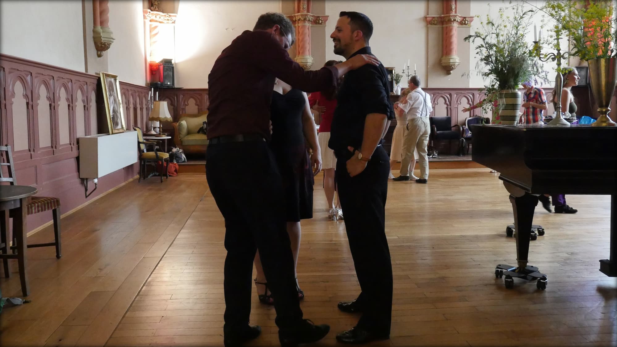 Schüler und Tango-Lehrer Fadi lachen freudig und ausgelassen miteinander