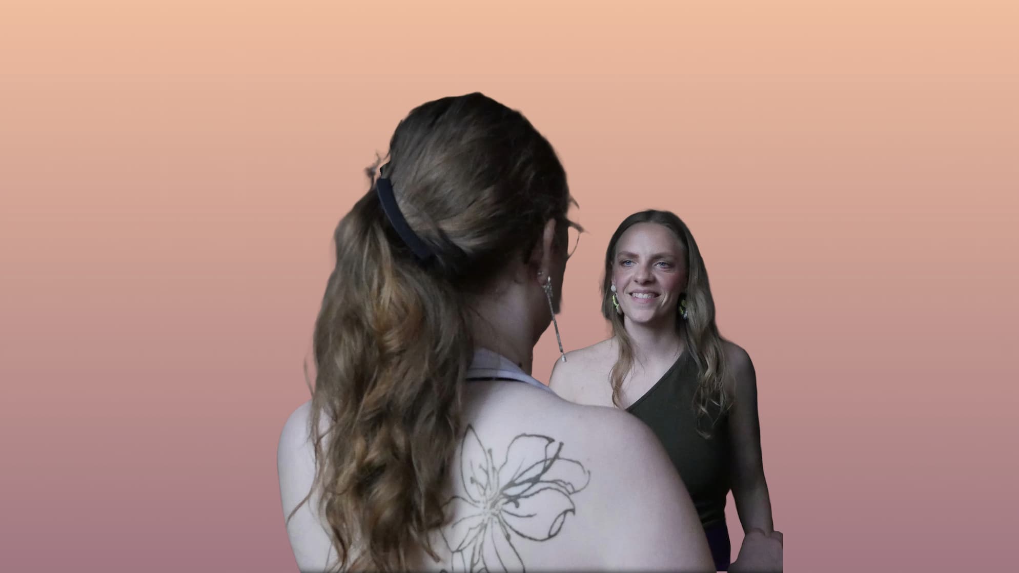 Tango teacher Juliana looks at a student standing with her back to the camera, against a warm gradient from peach to mauve